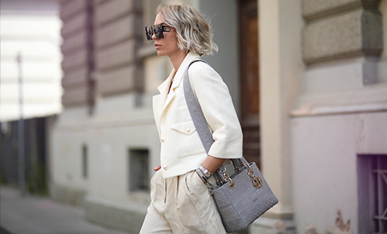 Žena v jarnej bielej bunde s kabelkou